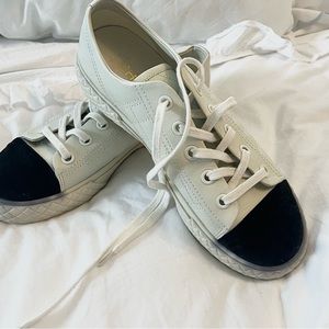 Coco Chanel sneakers with black felt ripped toes.